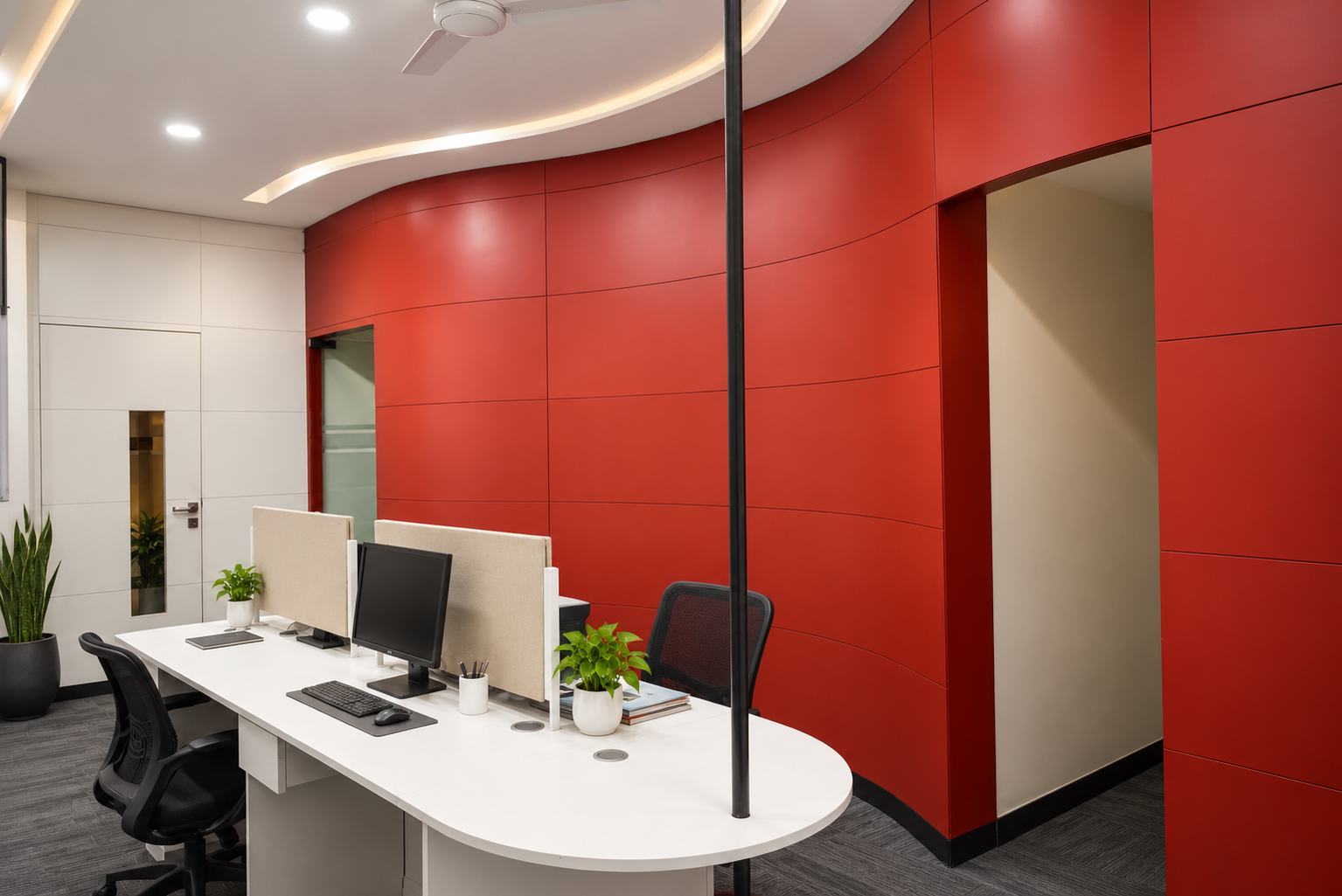 Employee workstations integrated against the curved red architectural wall